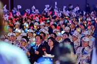 이재명 대통령과 김혜경 여사가 6월 25일 수원컨벤션센터에서 열린 6·25전쟁 제76주년 기념식에서 합창곡에 맞춰 태극기와 응원봉을 흔들고 있다.