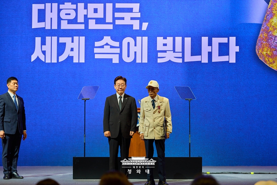 이재명 대통령이 6월 25일 수원컨벤션센터에서 열린 6·25전쟁 제76주년 기념식에서 비정규군 공로자 이영복 씨에게 화랑무공훈장을 수여한 후 기념촬영을 하고 있다.