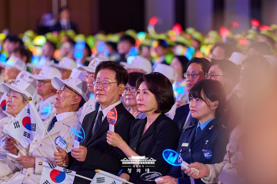 이재명 대통령과 김혜경 여사가 6월 25일 수원컨벤션센터에서 열린 6·25전쟁 제76주년 기념식에서 합창곡에 맞춰 태극기와 응원봉을 흔들고 있다.