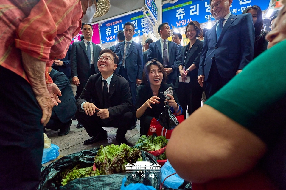 이재명 대통령과 김혜경 여사가 6월 25일 수원 팔달문시장에서 상인들과 대화하고 있다.