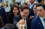 이재명 대통령이 6월 25일 수원 팔달문시장에서 시민들과 인사하고 있다.