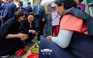 이재명 대통령과 김혜경 여사가 6월 25일 수원 팔달문시장에서 채소를 사고 있다.