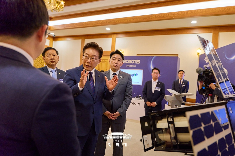 이재명 대통령이 6월 26일 청와대에서 '미래신안보 혁신기업 육성전략' 회의에 앞서 행사장 전시물 옵저버 위성 모형을 보고 있다.