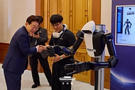 이재명 대통령이 6월 26일 청와대에서 '미래신안보 혁신기업 육성전략' 회의에 앞서 행사장 전시물 휴머노이드 로봇을 보고 있다.