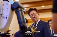 이재명 대통령이 6월 26일 청와대에서 '미래신안보 혁신기업 육성전략' 회의에 앞서 행사장 전시물 휴머노이드 로봇을 보고 있다.