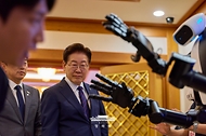 이재명 대통령이 6월 26일 청와대에서 '미래신안보 혁신기업 육성전략' 회의에 앞서 행사장 전시물 휴머노이드 로봇을 보고 있다.