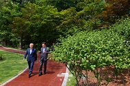 이재명 대통령과 문재인 전 대통령이 7월 1일 청와대에서 대화하며 오찬장인 상춘재로 이동하고 있다.