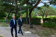 이재명 대통령과 문재인 전 대통령이 7월 1일 청와대에서 대화하며 이동하고 있다.