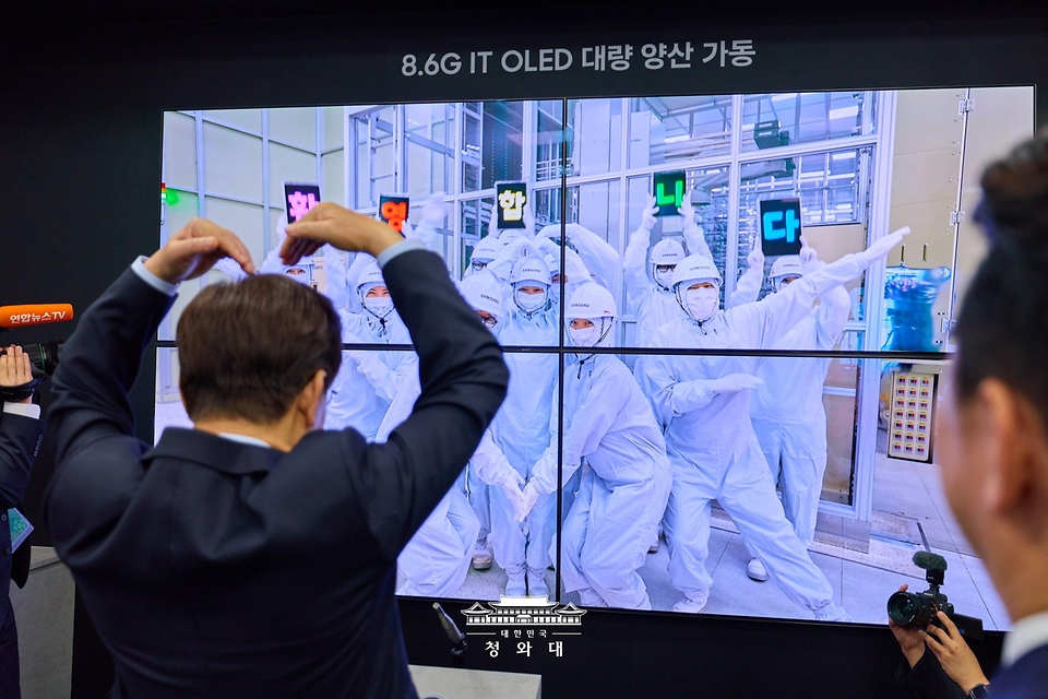 이재명 대통령이 7월 2일 충남 아산시에서 열린 충청권 첨단산업 발전비전 국민보고회에서 화상으로 생산라인 엔지니어들을 격려하고 있다.