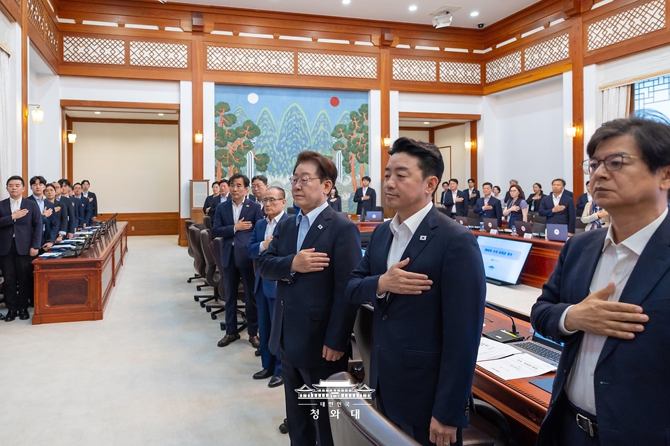 이재명 대통령이 7월 2일 청와대에서 열린 수석보좌관회의에서 국기에 경례하고 있다.