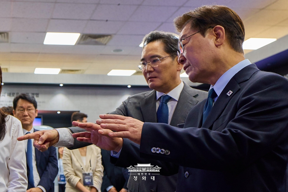 이재명 대통령이 7월 2일 충남 아산시에서 열린 충청권  첨단산업 발전비전 국민보고회에서 이재용 삼성전자 회장의 설명을 들으며 삼성디스플레이의 주요 제품을 관람하고 있다.