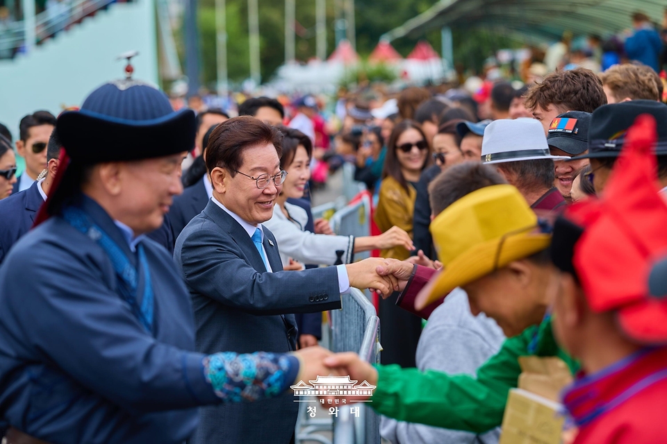몽골을 국빈방문 중인 이재명 대통령과 김혜경 여사가 7월 11일(현지 시간) 나담축제가 열리고 있는 울란바타르 전통 활쏘기 경기장에서 시민들과 인사하고 있다.