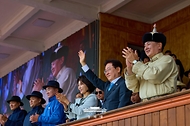 이재명 대통령이 7월 11일(현지 시간) 몽골 울란바타르 국립체육경기장에서 오흐나 후렐수흐 대통령과 나담축제 개막식 관람 중 손을 흔들고 있다.