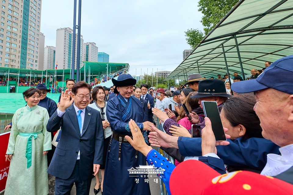 몽골을 국빈방문 중인 이재명 대통령과 김혜경 여사가 7월 11일(현지 시간) 나담축제가 열리고 있는 울란바타르 전통 활쏘기 경기장에서 시민들과 인사하고 있다.