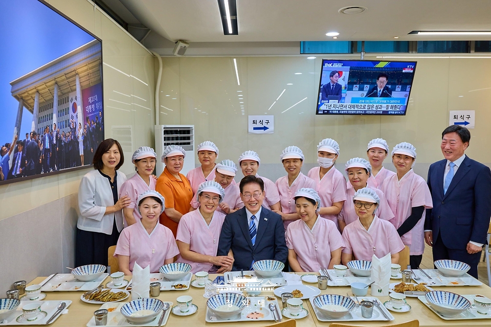 이재명 대통령이 7월 15일 청와대 여민관 구내식당에서 오찬 후 식당 직원들과 기념촬영을 하고 있다.