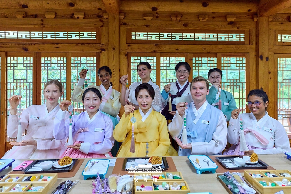 김혜경 여사가 7월 20일 서울 종로구 부암동 무계원 사랑채에서 외국인 청년들과 직접 만든 한국 전통공예 노리개를 들고 기념촬영을 하고 있다.