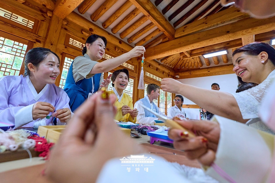 김혜경 여사가 7월 20일 서울 종로구 부암동 무계원 사랑채에서 코리아넷 명예 기자 및 해외 인플루언서 청년들과 함께 전통공예 노리개 제작 체험을 하고 있다.