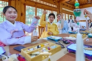 김혜경 여사가 7월 20일 서울 종로구 부암동 무계원 사랑채에서 외국인 청년들과 직접 만든 한국 전통공예 노리개를 들고 기념촬영을 하고 있다.