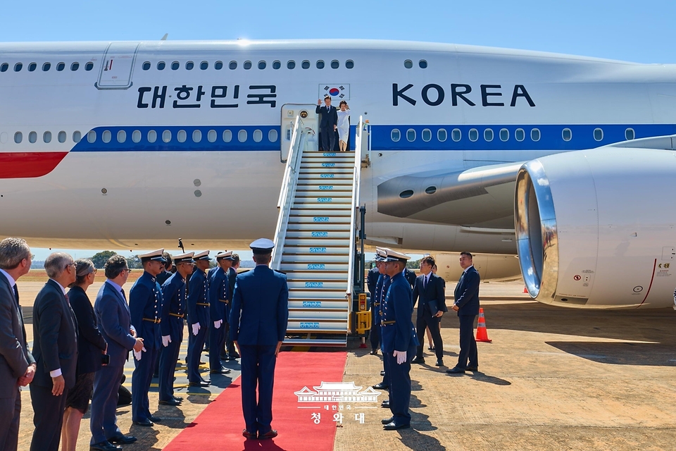 브라질을 국빈 방문한 이재명 대통령과 김혜경 여사가 7월 26일(현지 시간) 브라질리아 공군기지에 도착한 공군 1호기에서 환영객에게 인사하고 있다.