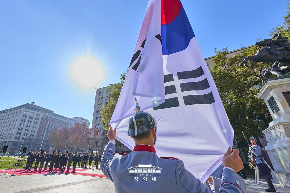 칠레를 공식 방문 중인 이재명 대통령과 김혜경 여사가 7월 30일(현지 시간) 산티아고 오히긴스 동상을 찾아 헌화 전 국기에 경례하고 있다.