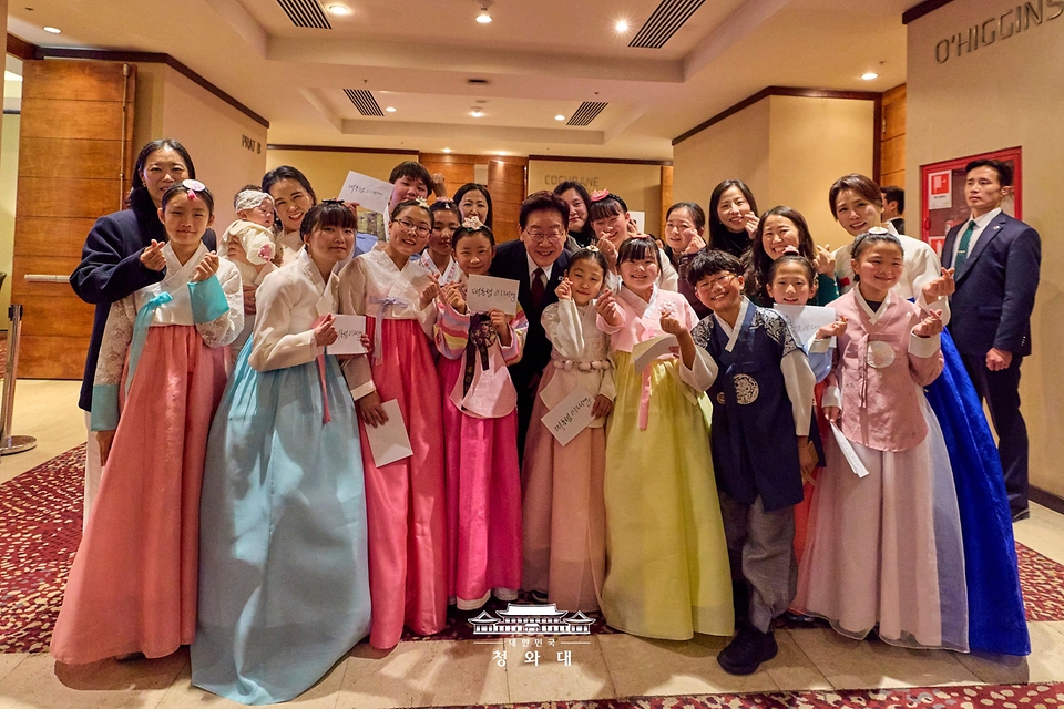 이재명 대통령과 김혜경 여사가 7월 29일(현지 시간) 칠레 산티아고 한 호텔에서 열린 동포 만찬간담회에서 어린이합창단원들과 기념 촬영을 하고 있다.