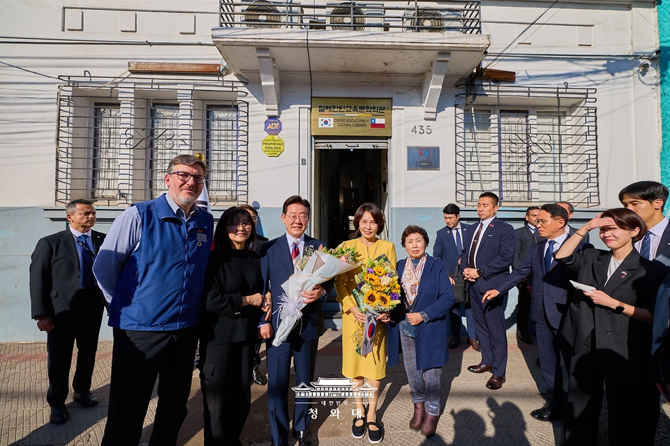 이재명 대통령과 김혜경 여사가 7월 30일(현지 시간) 칠레 산티아고의 '한국의 거리'에 있는 칠레한인회를 방문해 관계자들과 기념촬영을 하고 있다.