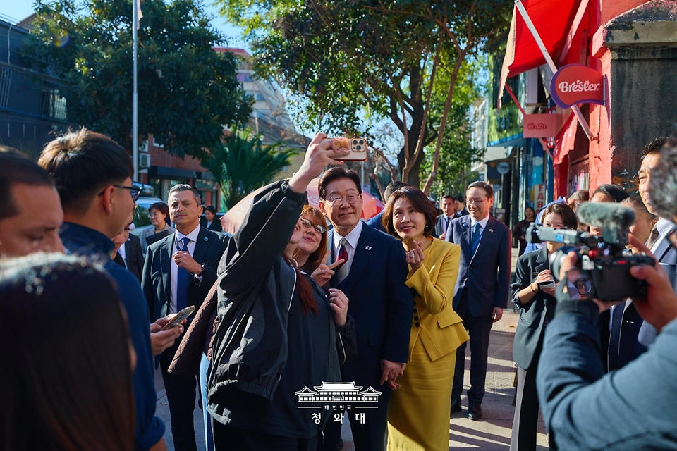이재명 대통령과 김혜경 여사가 7월 30일(현지 시간) 칠레 산티아고의 '한국의 거리'를 찾아 시민들과 기념 촬영을 하고 있다.