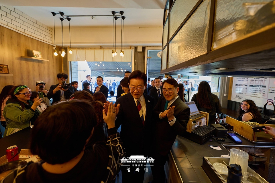 이재명 대통령이 7월 30일(현지 시간) 칠레 산티아고의 '한국의 거리'내 한 음식점을 찾아 시민들과 인사를 하고 있다.