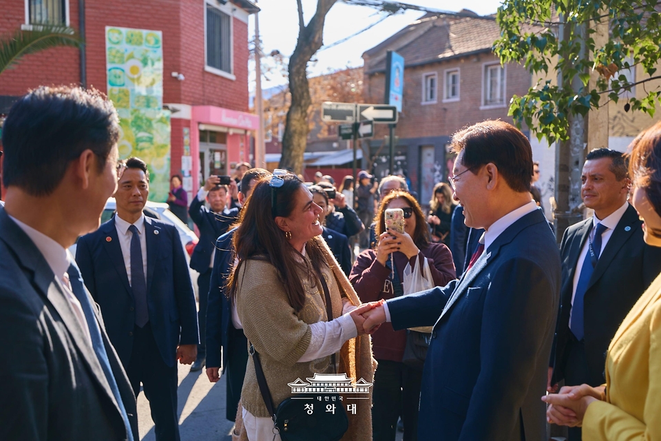 이재명 대통령이 7월 30일(현지 시간) 칠레 산티아고의 '한국의 거리'를 찾아 시민들과 인사를 하고 있다.