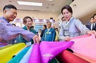 김혜경 여사가 8월 14일 서울 중구 동대문디자인플라자에서 열린 2026 한복상점 전시회에서 원단을 보고 있다.