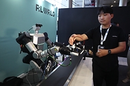 9월 22일 서울 강남구 코엑스 그랜드볼룸에서 열린 2026 휴머노이드 서밋 서울에 앞서 한 관계자가 피지컬 AI 휴머노이드 물류 로봇을 시연하고 있다. 