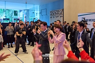 이재명 대통령과 김혜경 여사가 9월 25일(현지 시간) 멕시코시티 세계무역센터(WTC)에서 열린 랜덤 플레이 댄스 행사에서 참가자들을 향해 하트를 만들어 보이며 인사하고 있다.