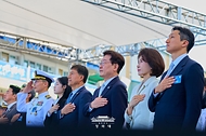 이재명 대통령과 김혜경 여사가 9월 30일 울산에서 열린 대호 김종서함 진수식에서 국기에 경례하고 있다.