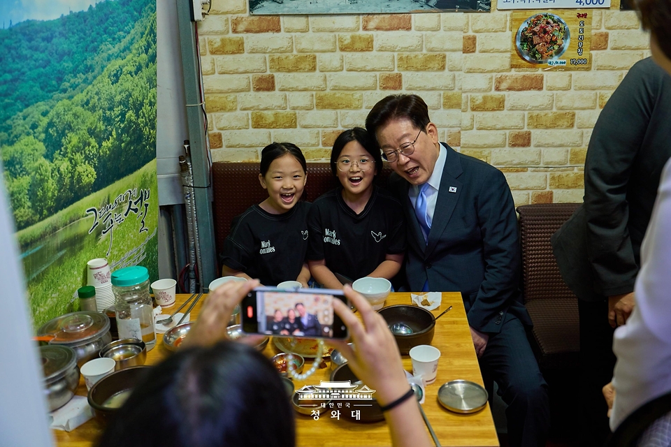 이재명 대통령과 김혜경 여사가 10월 2일 서울 서대문구 영천시장의 한 음식점에서 시민들과 기념촬영을 하고 있다.