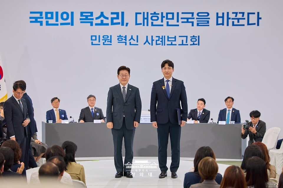 이재명 대통령이 10월 2일 세종특별자치시에서 열린 민원혁신 사례보고회에서 민원해결, 제도혁신 우수 공무원으로 선정된 이상우 중소벤처기업부 전산사무관에게 대통령 표창을 수여한 뒤 기념촬영을 하고 있다.