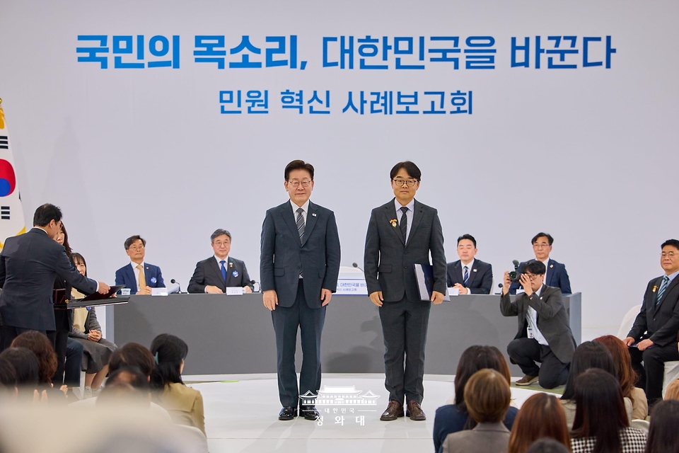 이재명 대통령이 10월 2일 세종특별자치시에서 열린 민원혁신 사례보고회에서 민원해결, 제도혁신 우수 공무원으로 선정된 윤선목 경상북도 구미시 민원봉사과 원스톱민원팀장에게 대통령 표창을 수여한 뒤 기념촬영을 하고 있다.