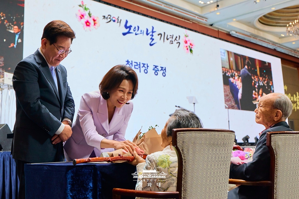 이재명 대통령과 김혜경 여사가 10월 2일 서울 한 호텔에서 열린 제30회 노인의 날 기념식에서 100세 어르신들에게 꽃다발을 전달하고 있다.