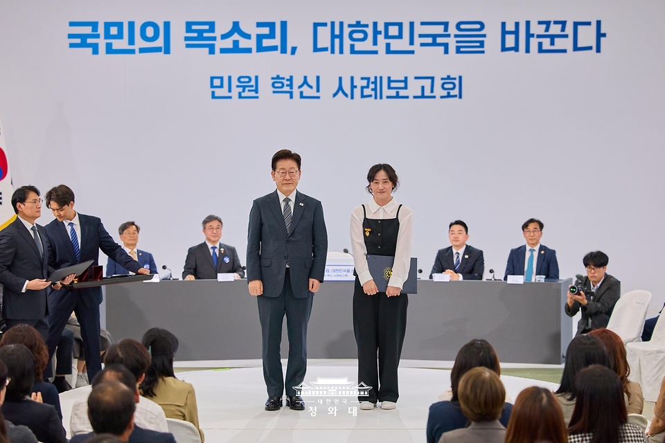 이재명 대통령이 10월 2일 세종특별자치시에서 열린 민원혁신 사례보고회에서 민원해결, 제도혁신 우수 공무원으로 선정된 정혜은 경상남도 창녕군 지방사회복지주사보에게 대통령 표창을 수여한 뒤 기념촬영을 하고 있다.