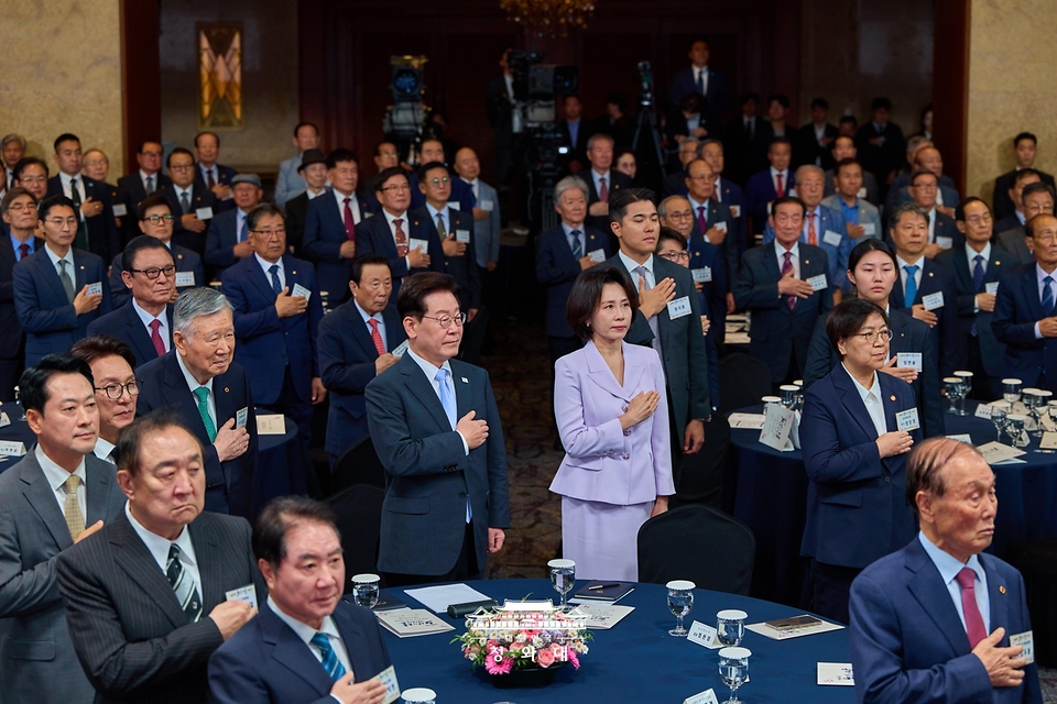 이재명 대통령과 김혜경 여사가 10월 2일 서울 한 호텔에서 열린 제30회 노인의 날 기념식에서 국기에 경례하고 있다.