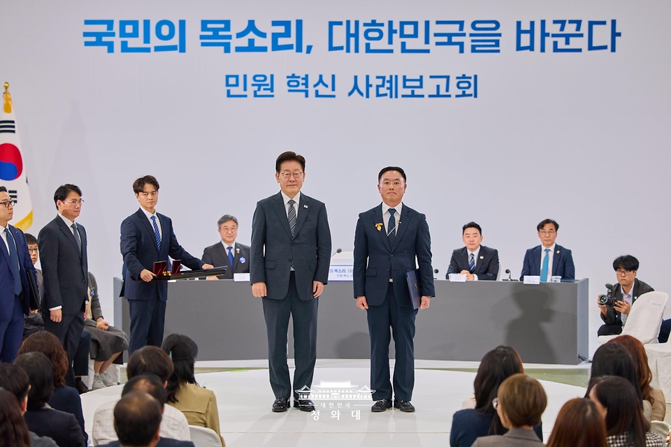 이재명 대통령이 10월 2일 세종특별자치시에서 열린 민원혁신 사례보고회에서 민원해결, 제도혁신 우수 공무원으로 선정된 송형근 전남광주통합특별시 지방시설주사에게 대통령 표창을 수여한 뒤 기념촬영을 하고 있다.