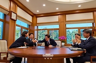 이재명 대통령이 10월 7일 청와대에서 한국형 발사체 누리호 5차 발사 성공 중계 화면을 보며 이해민 AI미래기획수석비서관과 악수하고 있다.