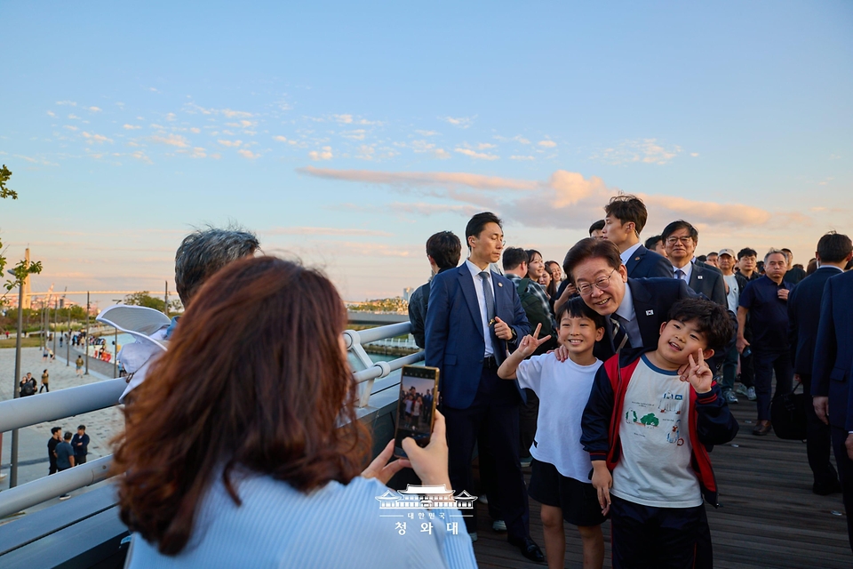 이재명 대통령이 10월 13일 흑상어 '부캉이'가 있는 부산 북항 친수공원을 방문해 시민들과 기념촬영을 하고 있다.
