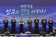 이재명 대통령이 10월 14일 청와대에서 열린 인구전략 비전선포식에서 참석자들과 함께 세리머니를 하고 있다.
