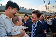이재명 대통령이 10월 13일 흑상어 '부캉이'가 있는 부산 북항 친수공원을 방문해 시민들과 인사하고 있다.