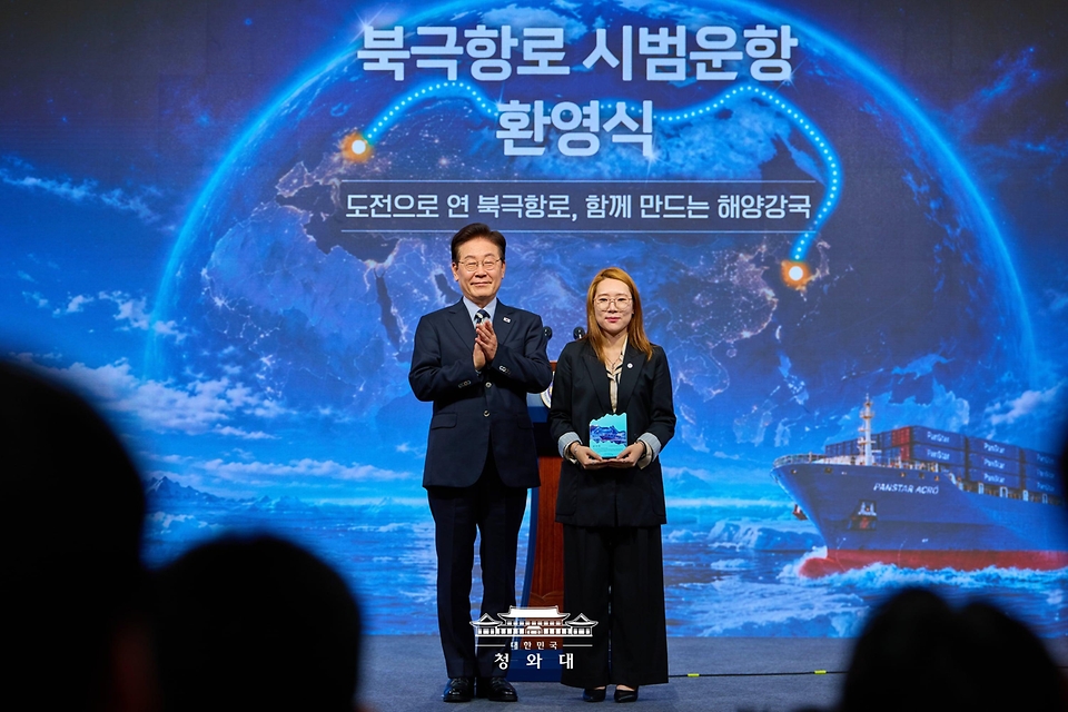 이재명 대통령이 10월 13일 부산에서 열린 북극항로 시범운항 환영식에서 팬스타 아크로호 승선원에게 감사패 전달 후 기념촬영을 하고 있다.