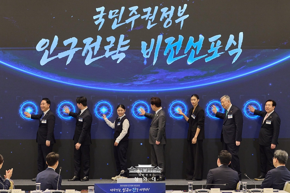 이재명 대통령이 10월 14일 청와대에서 열린 인구전략 비전선포식에서 참석자들과 함께 세리머니를 하고 있다.