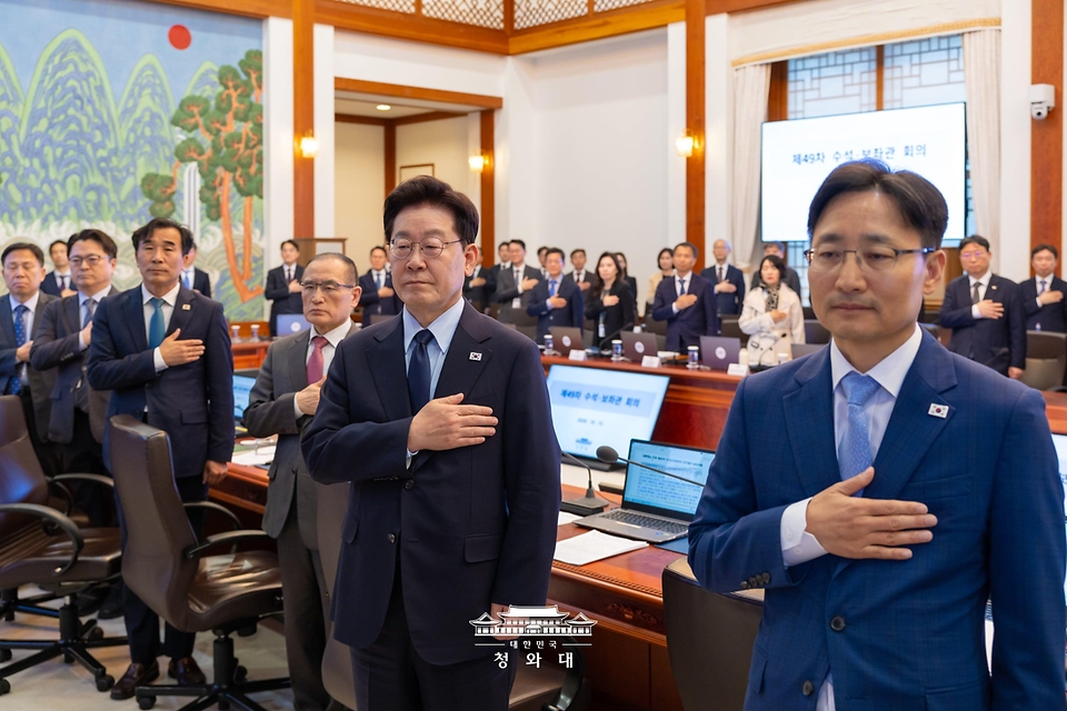 이재명 대통령이 10월 15일 청와대에서 열린 수석보좌관회의에서 국기에 경례하고 있다.