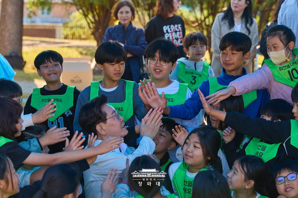 이재명 대통령이 10월 22일 전북 익산 왕궁초등학교에서 열린 가을 체육한마당에서 학생들과 인사하고 있다.