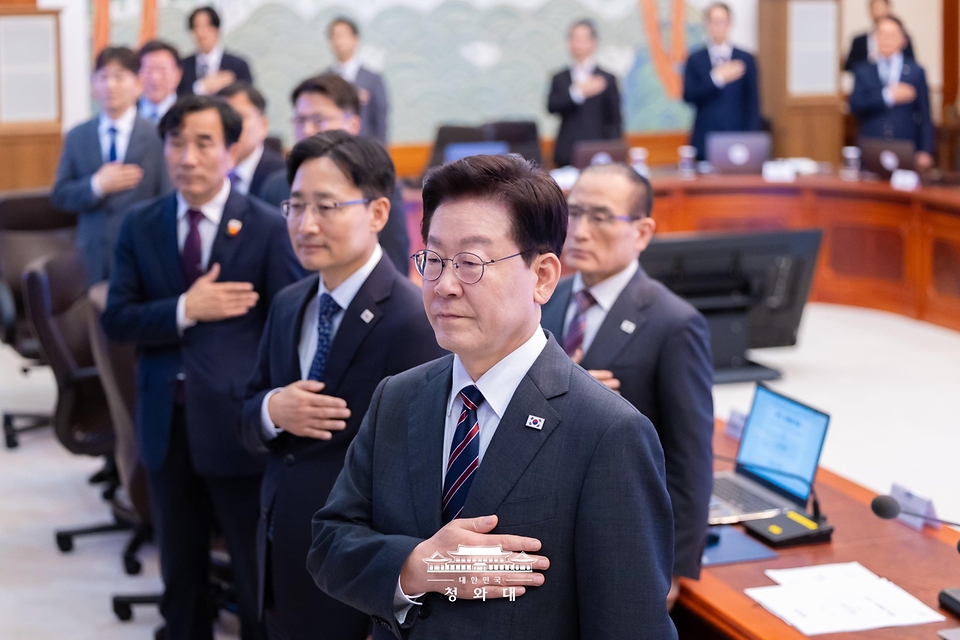이재명 대통령이 10월 22일 청와대에서 열린 수석보좌관회의에서 국기에 경례하고 있다. 