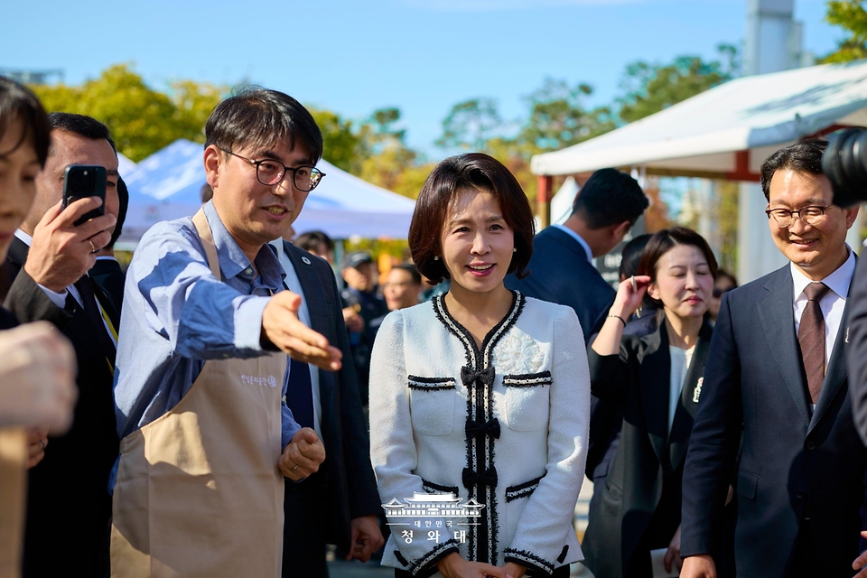 김혜경 여사가 10월 23일 서울 국립중앙박물관에서 열린 한식대축제에서 관계자의 안내를 받고 있다.